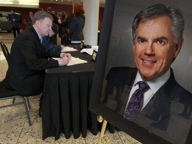 Vistors sign a book of condolence at the funeral for Jim Prentice in Calgary.