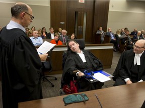 Greg McMeekin (centre) recites an oath with prompting from clerk Len Chernichko as he sits near lawyer Neil Dobson (R) while being ceil called to the bar during a ceremony at Calgary Courts Centre in Calgary, Alta., on Tuesday, Oct. 4, 2016.