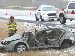 Emergency personel examine the scene of a fatal car accident ner Priddis, Alta, south of  Calgary, Alta on Friday October 7, 2016. Parts of southern Alberta saw snowfall for the first time this winter season, causing numerous accidents in annd around the Calgary area. Jim Wells//Postmedia