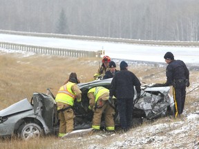 Emergency personel examine the scene of a fatal car accident ner Priddis, Alta, south of  Calgary, Alta on Friday October 7, 2016. Parts of southern Alberta saw snowfall for the first time this winter season, causing numerous accidents in annd around the Calgary area. Jim Wells//Postmedia