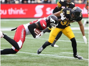 Calgary Stampeders wide receiver DaVaris Daniels (89) has his run stopped by Johnny Adams (39) during the first-half of CFL football action in Hamilton, Ont., on Saturday, October 1, 2016.