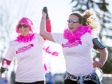 Felicity McRuer (L) and Lauren Batiuk run to the finish line in the Canadian Breast Cancer Foundation CIBC Run for the Cure at Southcentre Mall in Calgary, Alta., on Sunday, Oct. 2, 2016.