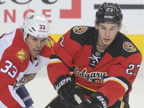 Sean Monahan from the Calgary Flames tangles with Willie Mitchell from the Florida Panthers in NHL hockey action at the Scotiabank Saddledome in downtown Calgary, Alta. on Wednesday January 13, 2016. Stuart Dryden/Calgary Sun/Postmedia Network