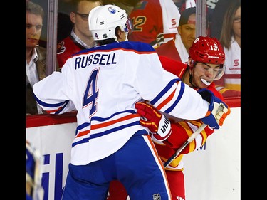 Edmonton Oilers Kris Russell collides with Johnny Gaudreau of the Calgary Flames during NHL hockey in Calgary, Alta., on Friday, October 14, 2016. AL CHAREST/POSTMEDIA