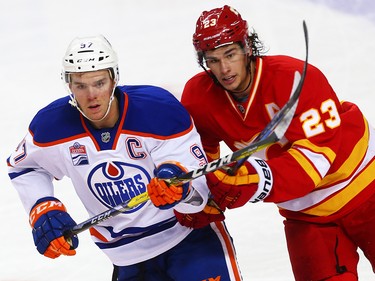 Edmonton Oilers Connor McDavid battles for the puck against Sean Monahan of the Calgary Flames during NHL hockey in Calgary, Alta., on Friday, October 14, 2016.