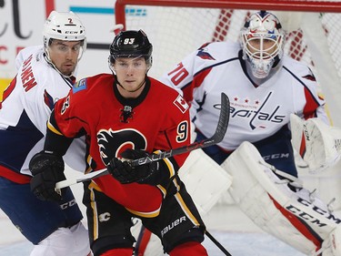 Calgary Flames Sam Bennett fight for position against Matt Niskanen, in front of  Washington Capitals goalie Braden Holtby during NHL hockey in Calgary, Alta., on Sunday, October 30, 2016.