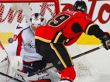 Washington Capitals goalie makes a save on a shot by Matthew Tkachuk of the Calgary Flames during NHL hockey in Calgary, Alta., on Sunday, October 30, 2016.