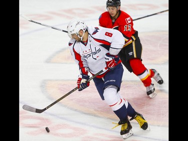 Washington Capitals Alex Ovechki  skates the puck up the ice against Johnny Gaudreau of the Calgary Flames during NHL hockey in Calgary, Alta., on Sunday, October 30, 2016.