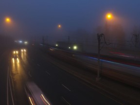 Train speeds by as traffic navigates a foggy Memorial Drive in Calgary. (Crystal Schick/Postmedia)