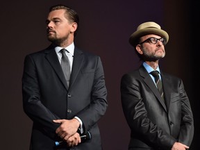 US actor Leonardo DiCaprio (L) and US director Fisher Stevens stand on stage during the Paris premiere of the documentary film "Before the Flood" on October 17, 2016 at the Theatre du Chatelet in Paris.