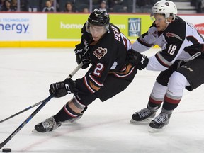 Jake Bean of the Calgary Hitmen tries to keep the puck away from Jack Flaman of the Vancouver Giants at the Scotiabank Saddledome in Calgary, Alta., on Monday, Oct. 10, 2016. Elizabeth Cameron/Postmedia