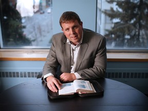 Jason Caldwell, father of twins Jordan and Evan Caldwell, looks through Jordan's bible in his Calgary office. Jason will be speaking at this year's Calgary Leadership Prayer Breakfast about how his faith has helped him and his family deal with the tragic loss of the two young men in a tobogganing accident at Canada Olympic Park last February. (Gavin Young/Postmedia)