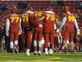 Jimmy Underdahl is helped off the field by teammates after injuring his knee in a game against the Manitoba Bisons at McMahon Stadium in Calgary, Alta., on Friday, Oct. 14, 2016.