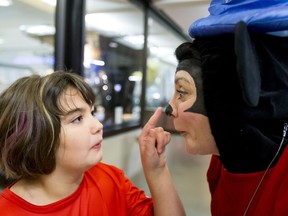 Kayda Joa, 9, pokes the nose of Susan Porter before boarding a flight at the Calgary International Airport on Wednesday, Oct. 19, 2016. Dreams Take Fight Calgary took 150 kids deserving a break from difficult situations for a one-day trip to the Magical Kingdom. It was Air Canada's 24th year for its charity event. Lyle Aspinall/Postmedia Network