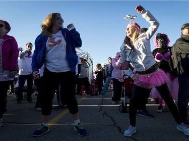 Maddison Eastgaard (L) and Christine Lerstol warm up before the start of the Canadian Breast Cancer Foundation CIBC Run for the Cure at Southcentre Mall in Calgary, Alta., on Sunday, Oct. 2, 2016.