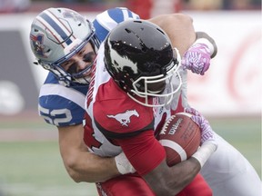 Montreal Alouettes linebacker Nicolas Boulay, left, tackles Calgary Stampeders running back Tory Harrison during first quarter CFL football action Sunday, October 30, 2016 in Montreal.