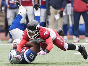 Montreal Alouettes slotback Nik Lewis, left, is tackled by Calgary Stampeders defensive back Brandon Smith during first half CFL football action Sunday, October 30, 2016 in Montreal.