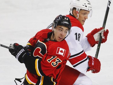 Calgary Flames Johnny Gaudreau collides with Jay McClement of the Carolina Hurricanes during NHL hockey in Calgary, Alta., on Thursday, October 20, 2016.