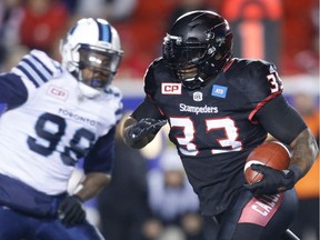 Calgary Stampeders Jerome Messam avoids a tackle by Tracy Robertson of the Toronto Argonauts during CFL football in Calgary, Alta., on Friday, October 21, 2016. AL CHAREST/POSTMEDIA
