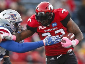 Montreal Alouettes' Ray Drew, left, grabs for Calgary Stampeders' Jerome Messam during first half CFL football action in Calgary, Saturday, Oct. 15, 2016.