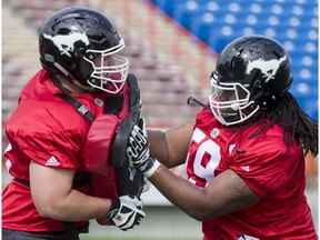 Roman Grozman (L) and Randy Richards run through a drill on Day 1 of the Calgary Stampeders rookie camp at McMahon Stadium in Calgary, Alta., on Thursday, May 26, 2016.