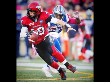 Calgary Stampeders Bo Levi Mitchell scrambles under pressure from Kyries Hebert of  the Montreal Alouettes during CFL football in Calgary, Alta., on Saturday, October 15, 2016. AL CHAREST/POSTMEDIA