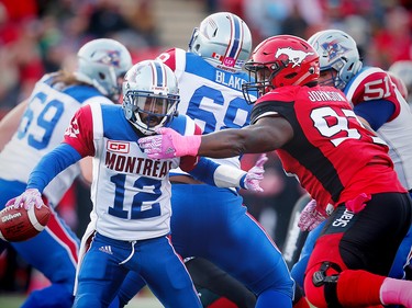 Montreal Alouettes quarterback Rakeem Cato scrambles under pressure from  Micah Johnson of the Calgary Stampeders during CFL football in Calgary, Alta., on Saturday, October 15, 2016.