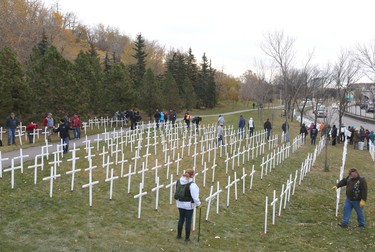 Volunteers set up crosses during the set-up at the Field of Crosses Memorial Project in Calgary, Alta on Saturday October 22, 2016 near Memorial Dr and Centre St NW. Starting November 1st to November 11th, over 3,200 crosses are being displayed on a 5 acre city park in military cemetery formation to memorialize southern Alberta soldiers who were killed in action.  Each cross is inscribed with the name, age at death, rank, regiment and date of death of a soldier who lost his or her life in a foreign land, fighting for the freedoms we all enjoy today. Jim Wells/Postmedia