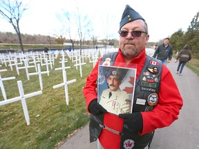 Steve Merritt holds a photo of his brother Jim as he pauses during the set-up at the Field of Crosses Memorial Project in Calgary, Alta on Saturday October 22, 2016 near Memorial Dr and Centre St NW. Steve later placed the photo on his brother's cross for the first time. Starting November 1st to November 11th, over 3,200 crosses are being displayed on a 5 acre city park in military cemetery formation to memorialize southern Alberta soldiers who were killed in action.  Each cross is inscribed with the name, age at death, rank, regiment and date of death of a soldier who lost his or her life in a foreign land, fighting for the freedoms we all enjoy today. Jim Wells/Postmedia