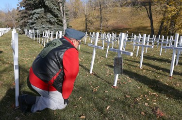 Steve Merritt places a photo of his brother Jim on his cross during the set-up at the Field of Crosses Memorial Project in Calgary, Alta on Saturday October 22, 2016 near Memorial Dr and Centre St NW. Starting November 1st to November 11th, over 3,200 crosses are being displayed on a 5 acre city park in military cemetery formation to memorialize southern Alberta soldiers who were killed in action.  Each cross is inscribed with the name, age at death, rank, regiment and date of death of a soldier who lost his or her life in a foreign land, fighting for the freedoms we all enjoy today. Jim Wells/Postmedia