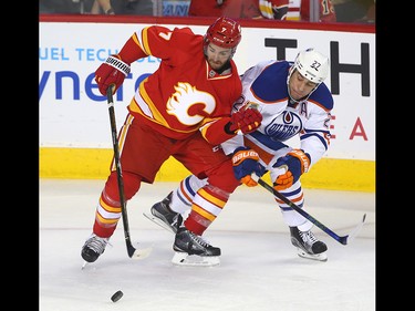 Flames TJ Brodie (L) battles Oilers Milan Lucic during NHL action between the Edmonton Oilers and the Calgary Flames in Calgary, Alta. on Friday October 14, 2016. Jim Wells/Postmedia