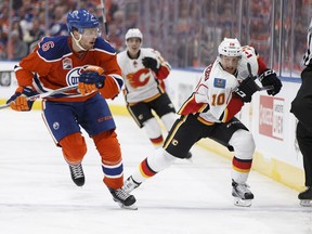 Edmonton's Adam Larsson chases Kris Versteeg during Wednesday's season opener between the Flames and Oilers.