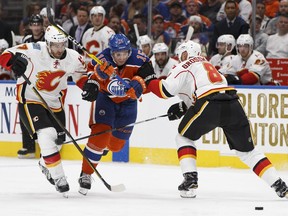 Edmonton's Tyler Pitlick (15) battles Calgary's TJ Brodie (7) and Nicklas Grossman (8) during the third period of a NHL game between the Edmonton Oilers and the Calgary Flames at Rogers Place in Edmonton, Alberta on Wednesday, October 12, 2016.
