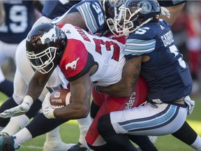 Toronto Argonauts Jermaine Gabriel and Calgary Stampeders Jerome Messam during 1st half CFL action at BMO Field in Toronto, Ont. on Monday October 10, 2016.