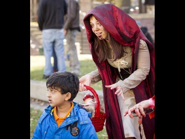 'Little Dead Riding Hood' Madeleine Beaton creeps up on a kid before the Zombie Walk in downtown Calgary, Alta., on Saturday, Oct. 15, 2016. The Zombie Walk is an annual event held mostly for fun but also to raise money and cash for the Calgary Food Bank. Lyle Aspinall/Postmedia Network