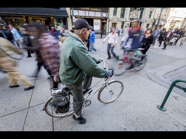 A cyclist waits for the undead to pass during the Zombie Walk in downtown Calgary, Alta., on Saturday, Oct. 15, 2016. The Zombie Walk is an annual event held mostly for fun but also to raise money and cash for the Calgary Food Bank. Lyle Aspinall/Postmedia Network