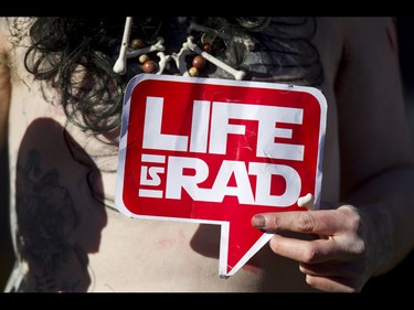 A sign is held before the Zombie Walk in downtown Calgary, Alta., on Saturday, Oct. 15, 2016. The Zombie Walk is an annual event held mostly for fun but also to raise money and cash for the Calgary Food Bank. Lyle Aspinall/Postmedia Network