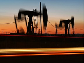 CULVER CITY, CA - APRIL 25:  Car lights are seen streaking past an oil rig extracting petroleum as the price of crude oil rises to nearly $120 per barrel, prompting oil companies to reopen numerous wells across the nation that were considered tapped out and unprofitable decades ago when oil sold for one-fifth the price or less, on April 25, 2008 in the Los Angeles area community of Culver City, California. Many of the old unprofitable wells, known as 'stripper wells', are located in urban areas where home owners are often outraged by the noise, smell, and possible environmental hazards associated with living so close to renewed oil drilling. Since homeowners usually do not own the mineral rights under their land, oil firms can drill at an angle to go under homes regardless of the desires of residents. Using expensive new technology and drilling techniques, California producers have reversed a long decline of about 5 percent annually with an increased crude flow of about 2 1/2 million barrels in 2007 for the first time in years.  (Photo by David McNew/Getty Images) ORG XMIT: 80848321