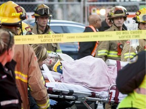 A man estimated to be in his 20's is wheeled on a stretcher to a waiting ambulance after being hit by a Ctrain in downtown Calgary, Alta., on Tuesday, Nov. 29, 2016. The man was hit and dragged about two blocks before the train stopped; he went to hospital in life-threatening condition. Lyle Aspinall/Postmedia Network