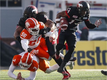 B.C. Lions' Richie Leone, bottom left, and Solomon Elimimian let Calgary Stampeders' Roy Finch, right, get away from them during first quarter CFL Western Final football action, in Calgary on Sunday, Nov. 20, 2016.