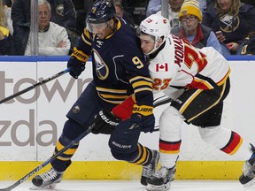 Buffalo Sabres forward Evander Kane (9) and Calgary Flames center Sean Monahan (23) battle for the puck during the first period of an NHL hockey game, Monday, Nov. 21, 2016, in Buffalo, N.Y.