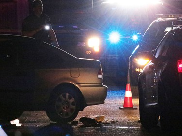 A damaged car with its doors open and a shoe near the rear tire sits at the centre of a scene of an officer involved shooting in an alley in Dover on Thursday night November 3, 2016.