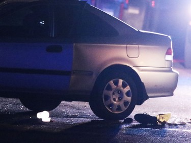 A damaged car with its doors open and a shoe near the rear tire sits at the centre of a scene of an officer involved shooting in an alley in Dover on Thursday night November 3, 2016.