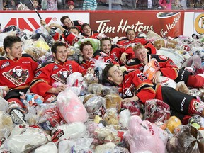 The Calgary Hitmen celebrate by jumping into thousands of stuffies in the annual Teddy Bear Toss game on Saturday November 26, 2016. The Hitmen were taking on the Lethbridge Hurricanes in the game and Micheal Zipp scored the first Hitmen goal to trigger the avalanche of teddies. GAVIN YOUNG/POSTMEDIA