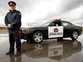 Inspector Ken Thrower stands next to the black and white Calgary Police Service vehicle in Calgary, Alberta May 3, 2012.