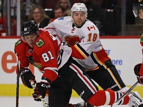 CHICAGO, IL - NOVEMBER 01: Marian Hossa #81 of the Chicago Blackhawks is knocked to the ice by Matt Stajan #18 of the Calgary Flames at the United Center on November 1, 2016 in Chicago, Illinois.