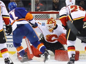 NEW YORK, NY - NOVEMBER 28: Brian Elliott #1 of the Calgary Flames makes the third period save on Shane Prince #11 of the New York Islanders at the Barclays Center on November 28, 2016 in the Brooklyn borough of New York City.