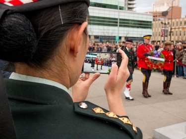 Calgary Highlanders cadets Captain Julie Sun takes pictures of wreaths being laid at the cenotaph at Central Memorial Park for Remembrance Day ceremonies in Calgary, Ab., on Friday November 11, 2016.