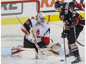 Calgary Hitmen Beck Malenstyn gets in close on Moose Jaw Warriors goalie Brody Wilms in WHL action at the Scotiabank Saddledome in Calgary, Alberta, on Friday, November 25.