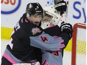 Calgary Hitmen Kyle Dumba is hugged by Hitmen Micheal Zipp after holding off the Swift Current Broncos in WHL action at the Scotiabank Saddledome in Calgary, Alberta, on Saturday, November 5. The Hitmen beat the Broncos 3-2.